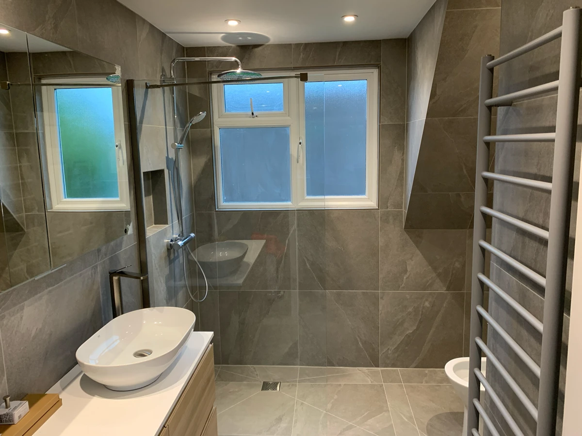 A bathroom with a shower, sink, and toilet.