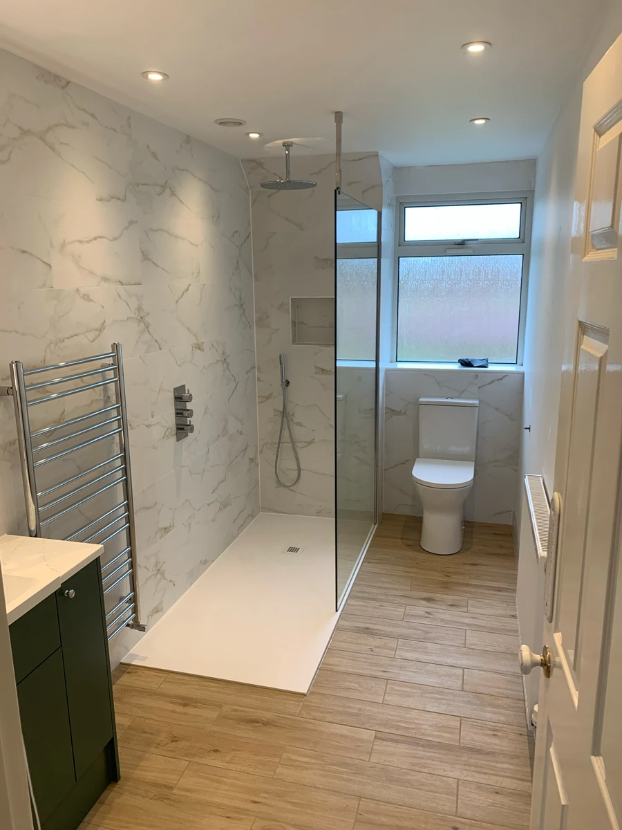 A bathroom with a walk in shower next to a toilet.