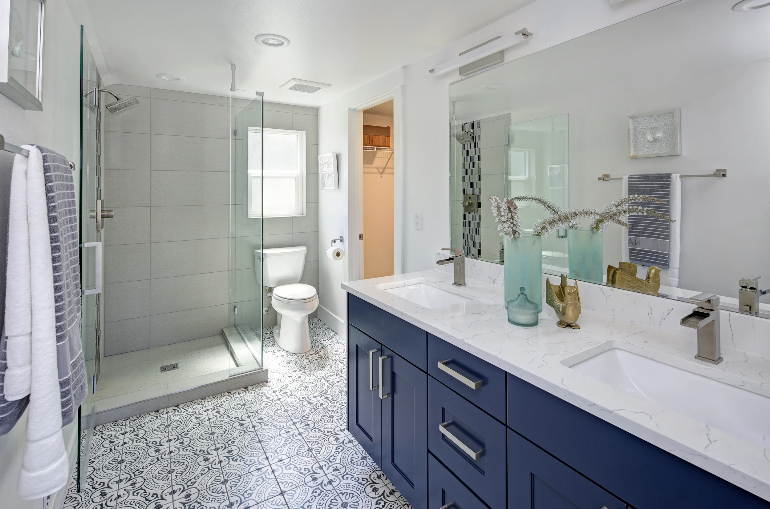A bathroom with blue cabinets and a white toilet.