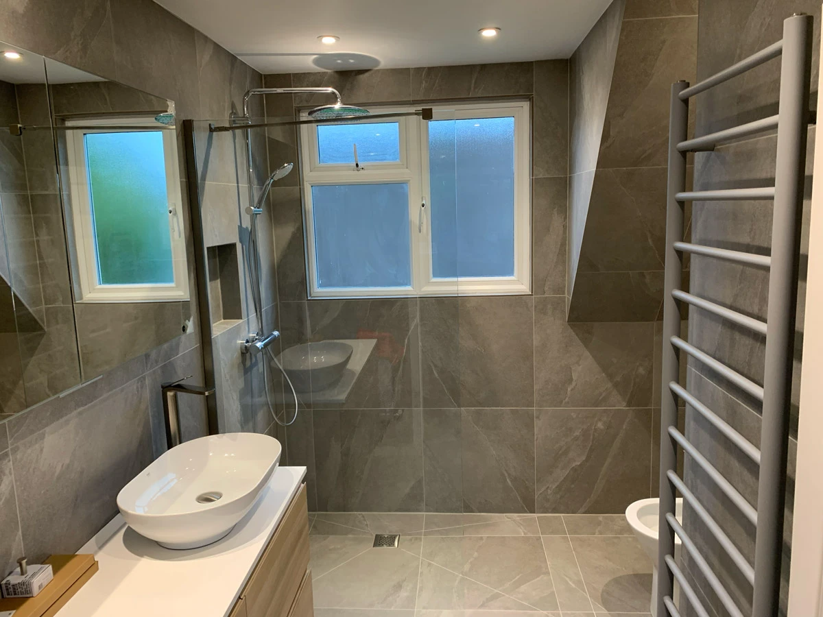 A bathroom with a sink, toilet, and shower.